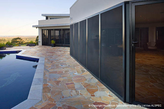 Invisi-Gard security screen doors shown on a beautiful coastal property with a pool